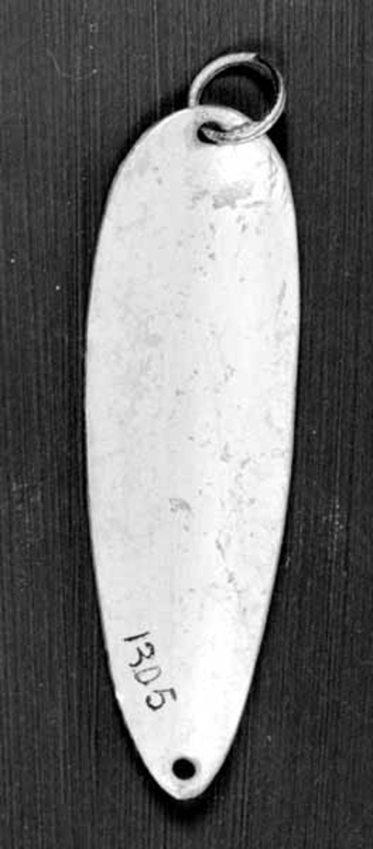 Skjesluk, brukt av Brynjulf Styve under fiske i Lågen. 
Sluken som er aluminiumsfarvet har et hull i hver ende, og ring i det ene. 