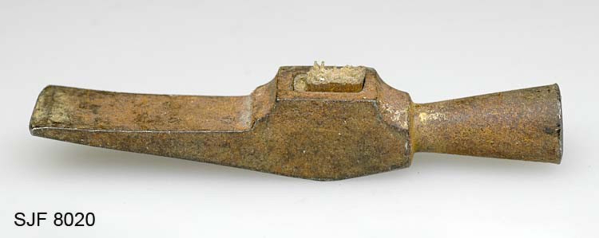 Liten hammer med knekt skaft. Dette verktøyet har tilhørt knivmakeren Ole Jacobsen Vestby (1875-1954) fra Nord-Odal i Hedmark. Hammerhodet er 8,7 centimeter høyt. I den ene enden er det en sirkelrund slagdel, der banen har en diameter på 1,4 cenitimeter. Derfra avtar diameteren oppover mot hammerhodets midtparti, som har et rektangulært tverrrsnitt (1,5 X 1,3 centimeter) og et rektangulært «øye» (skafthull - 0,7 X 1,1 centimeter). I dette øyet sitter det et bruddstykke av et treskaft. Den øvre enden av hammerhodet består av en slakt bakoverskrånende penn som er 1,5 centimeter bred i yttrerenden.