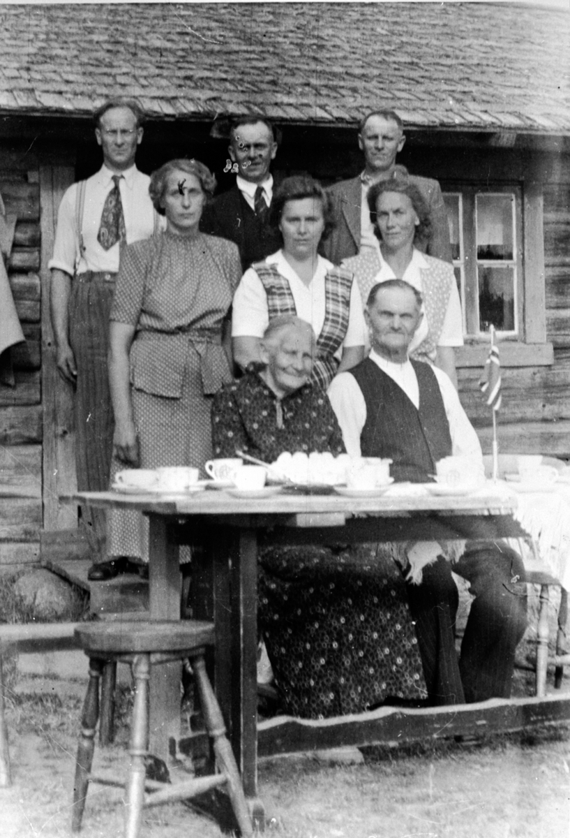 Familie Sandbæk på Trosterud, Helgøya. Foran fra venstre er Oline Retiniusdatter Skramstad f. 1871, Ole Antonsen Sandbæk f.1874. Midten fra venstre er Solveig f.1915, Signe f. 1911, Olga f.1908. Bak fra venstre er Olaf f.1905, Bjarne f.1902, Asbjørn f.1900.
