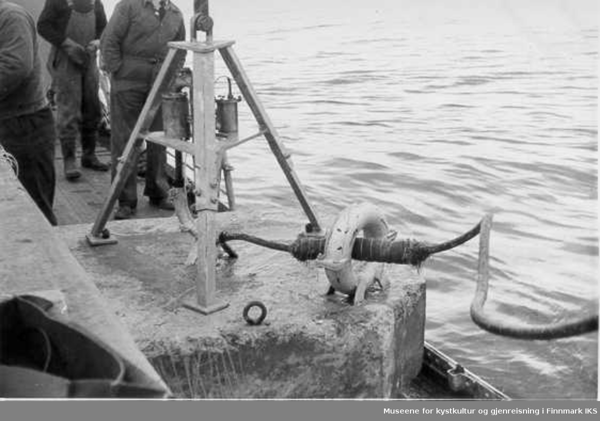 Bølgemåleren er heist ombord i en båt og er klar for utsetting på ca. 18 m dyp utfor Svartoksmoloen. 3 menn står på dekket, ca 1960