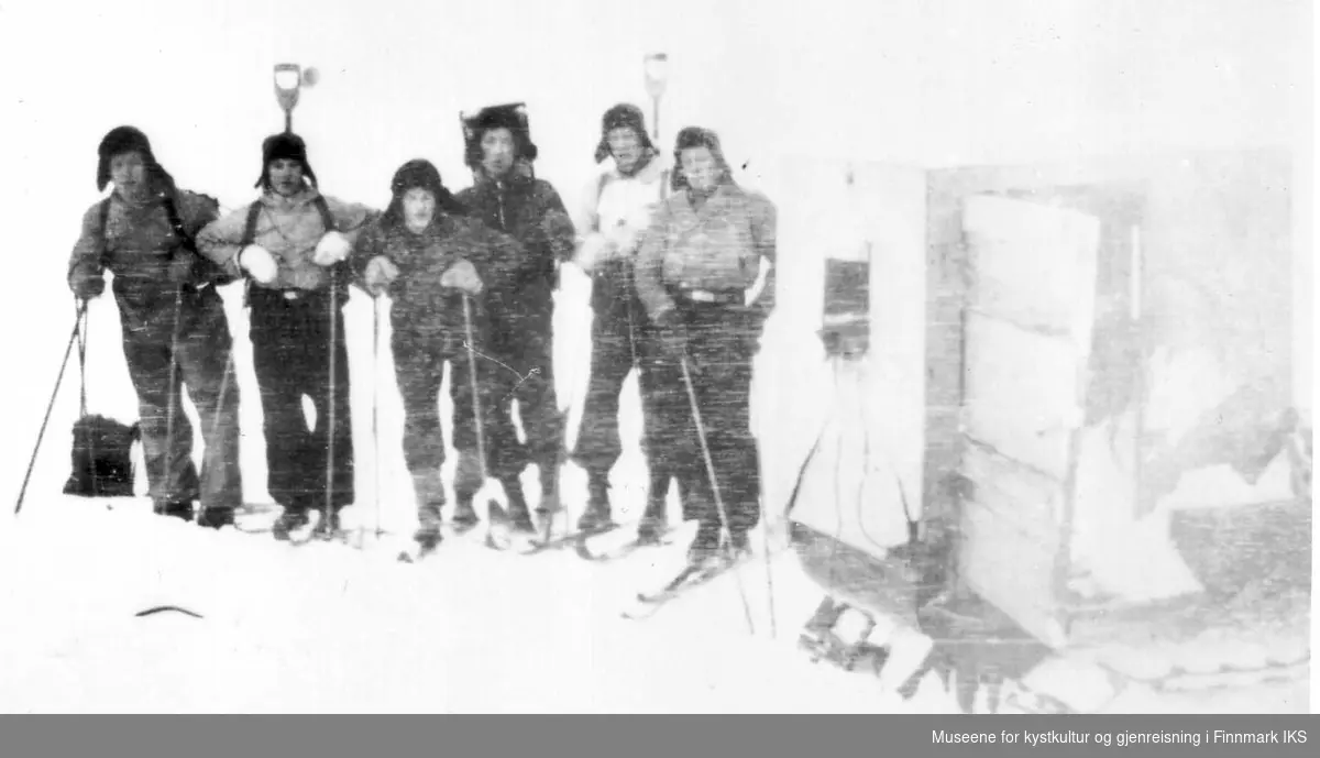 På ski foran vinterinngangen til Varangerkraftstasjonen. Bærerene brakte proviant opp til stasjonen. Fra venstre: Aksel Olsen, ukjent, Arne Olsen, Agnar Jensen, Halvor Haukland og ukjent. 1941
