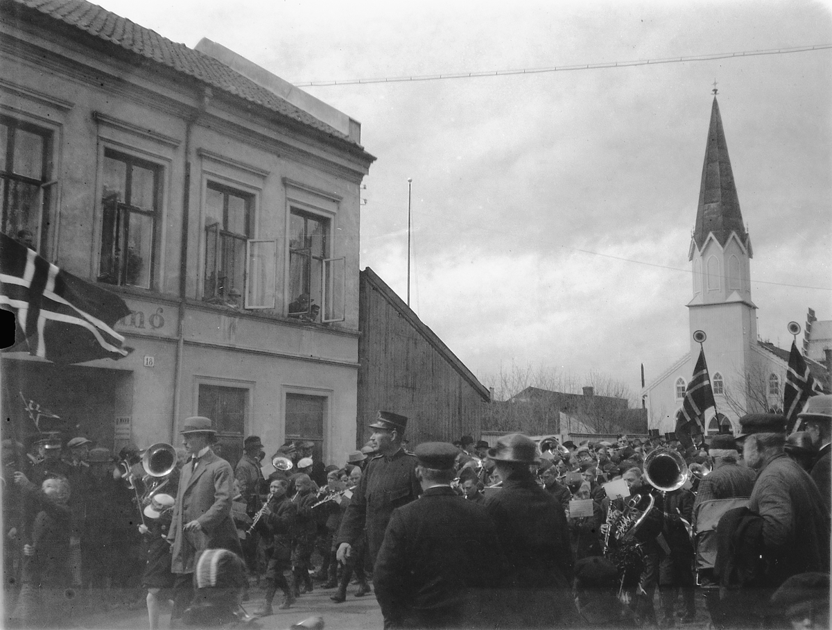 17. mai tog i Grønnegata, Hamar. Korps spiller i gata. Metodistkirken i bakgrunnen. 