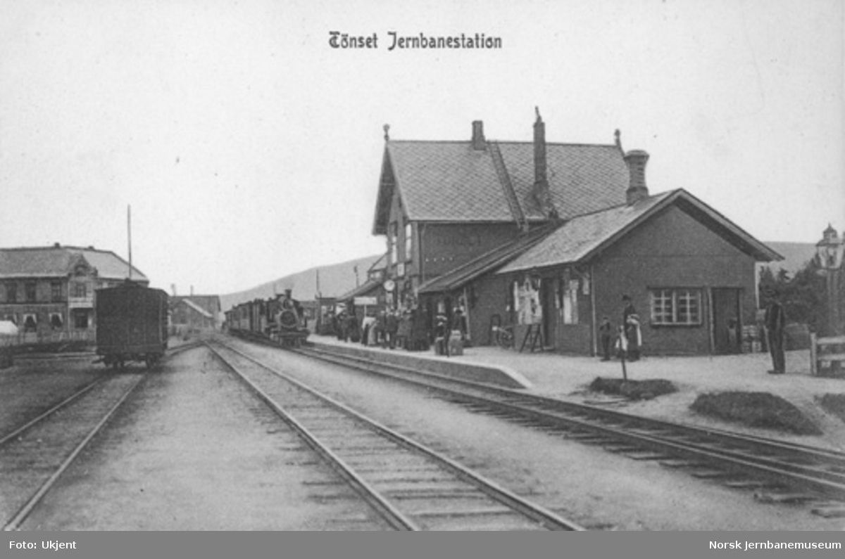 Tynset stasjon med ankommende tog i spor 1 og mange reisende