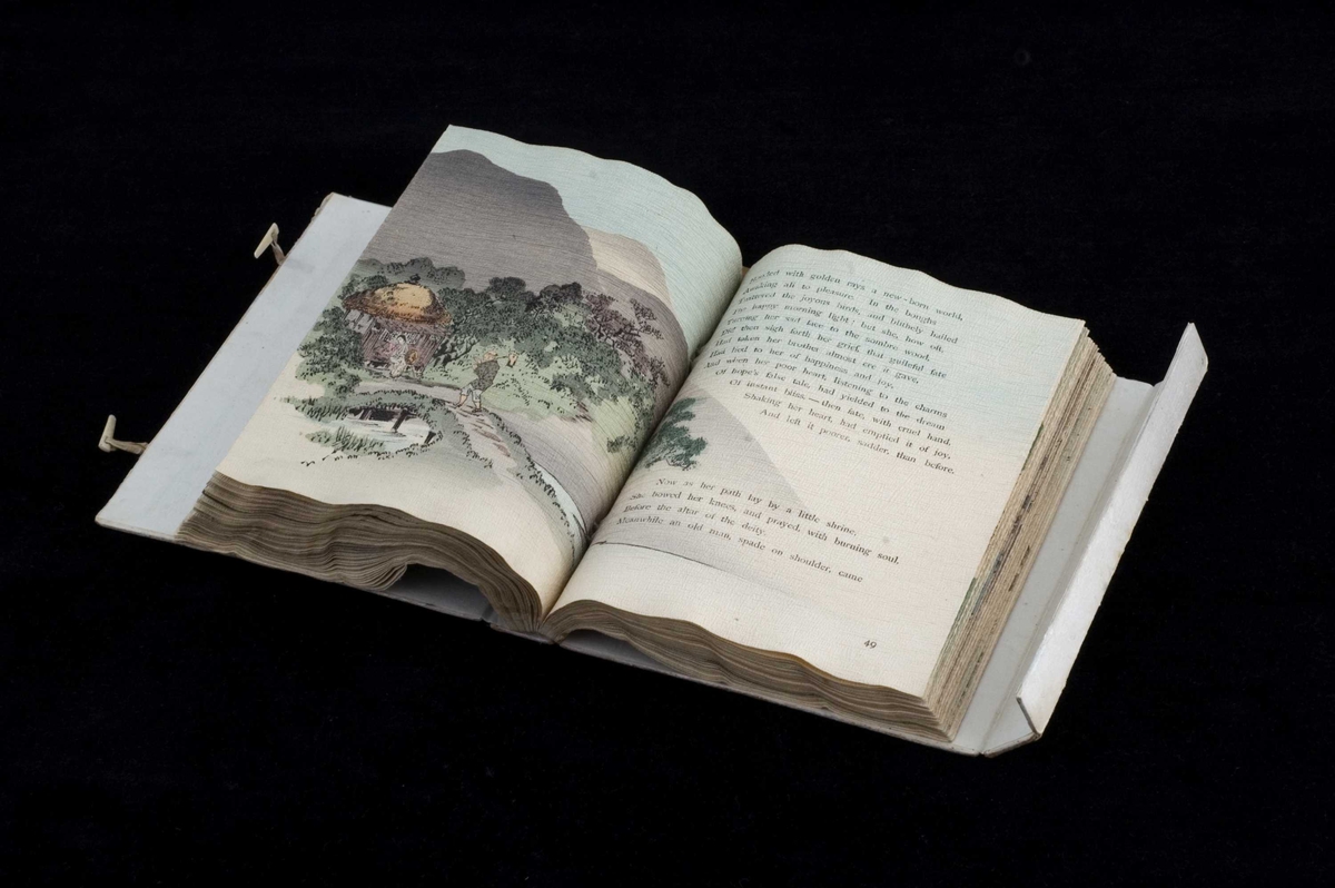 Bok av foldet, uskåret kreppapir med trykket tekst og tresnittillustrasjoner. Boken har original omslagskassett og er lagt i en boks av nyere dato.