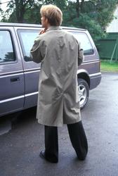 Regntøy, mann i frakk ved bil, bakfra