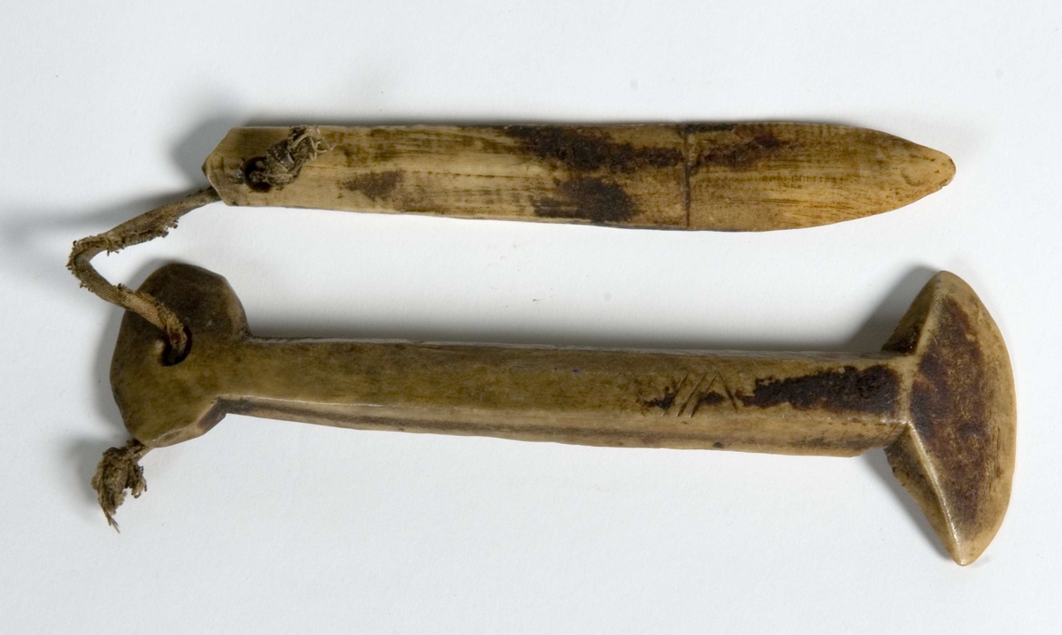 lett buet knivformet stykke med fasettskåret skaft. Hull i enden og en skåret markering inntil blad. Bladet er slipt begge sider. Tekstilbånd fra hull til NFSA.1643.