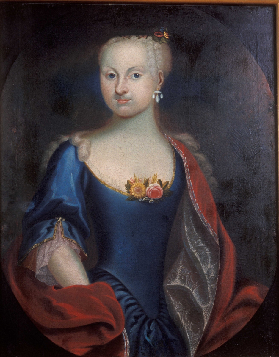 Portrett, halvfigur. Kvinne iført utringet, dypblå kjole og rødt draperi. Blomster i utringning. Pudret hår. Trolig Kathrine Chrystie (f. 1735).