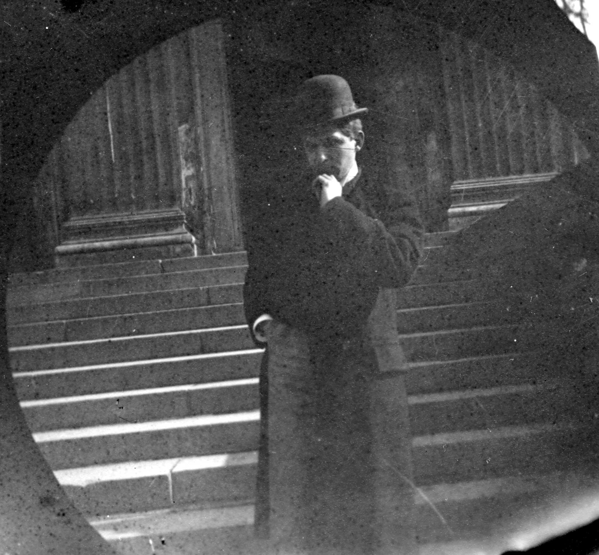 Edgar Odell Lavett med hatt, frakk og stokk står foran trapp.