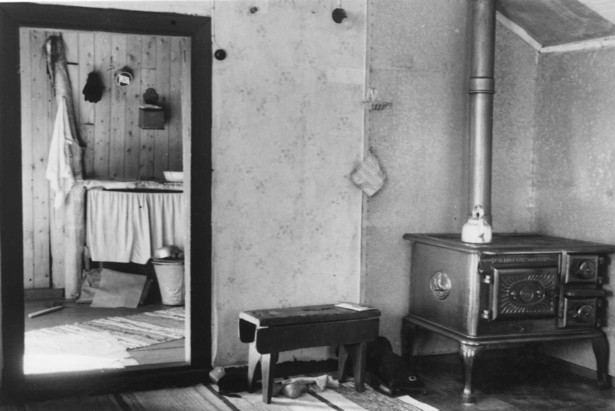 Interiør i Einar Pedersens boliggamme, i hjørne står vedkomfyren og en benk. Ánnejohka - Vestre Jakobselv, Finnmark  1951.