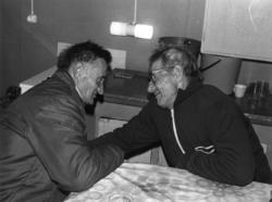 To menn sitter i samtale ved et kjøkkenbord. Palojärvi 1972.