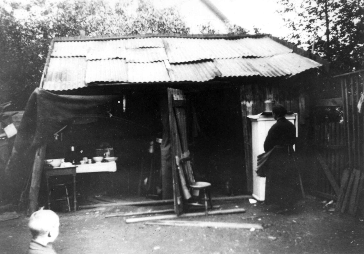Skur med boligfunksjon?, Oslo. Åpen forside med møbler og dekketøy.
Fra boliginspektør Nanna Brochs boligundersøkelser i Oslo 1920-årene.