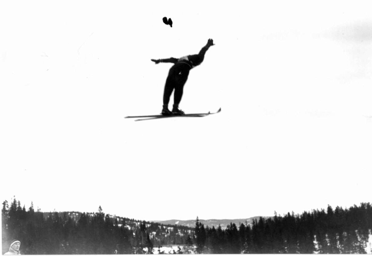 Ski. Hopprenn. Holmenkollen, Oslo 1934. 
Hopper i svevet. Nordmarka ses i bakgrunnen.