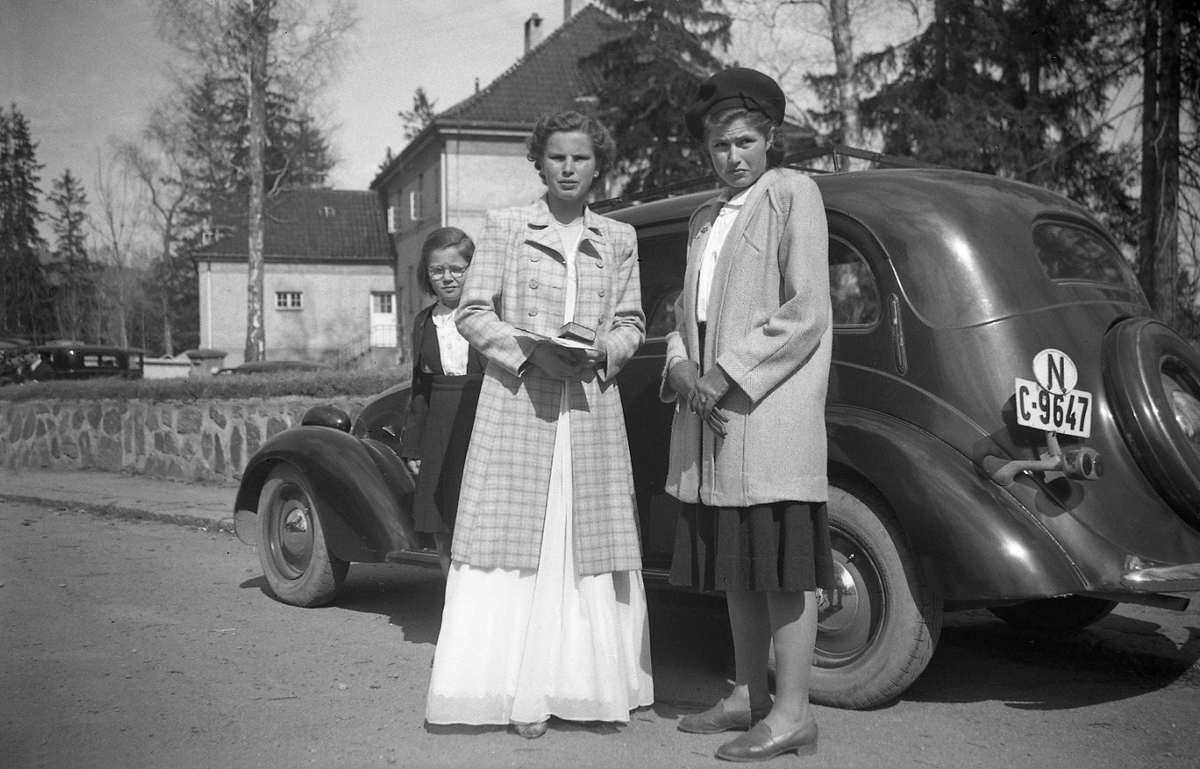 Konfirmanten Siri Arentz og søstrene Guri og Kari ved bilen foran hjemmet i P.T. Mallingsvei 4 på Bygdøy. Fotografert 1947.