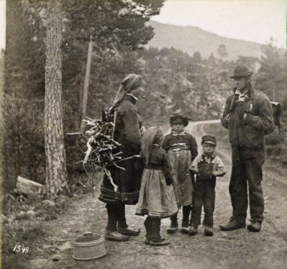 Familie på skogstur, iført hverdagsdrakter fra Setesdalen, Aust-Agder. 