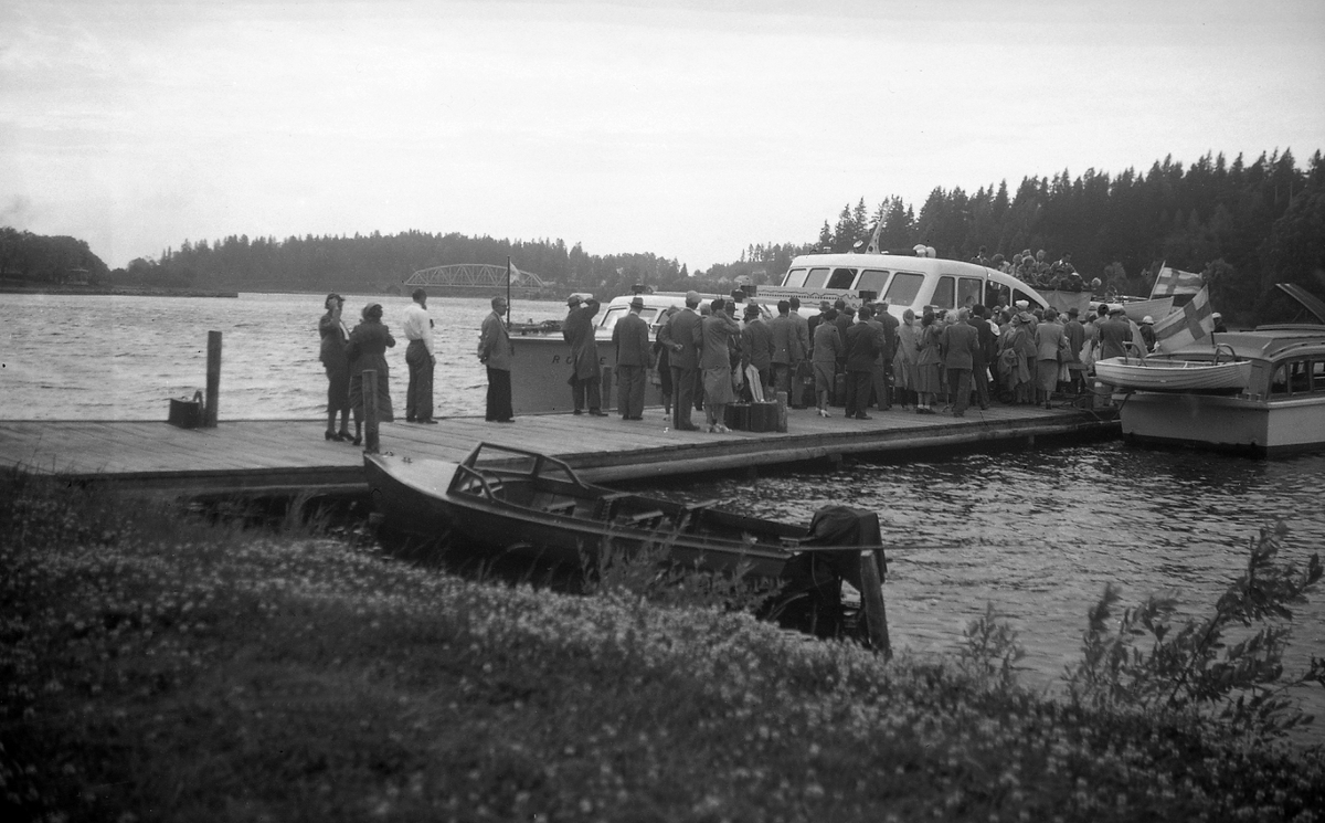 Passasjerer venter på å gå om bord i sjøbussen ved Aulanko i Finland. Fotografert 1951.