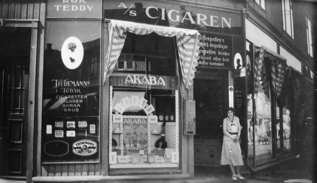 En kvinne står i inngangen til tobakksforretningen Cigaren A/S i Tønsberg, 1932.