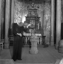 Gjermund Haugen spiller hardingfele ved altertavlen i Heddal