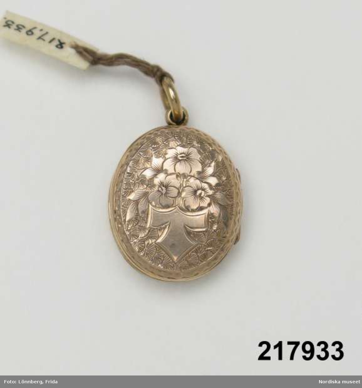 Katalogkort:
"Medaljong, guld med blå emalj,
H. 2,7 cm

Innehåller hårlock."