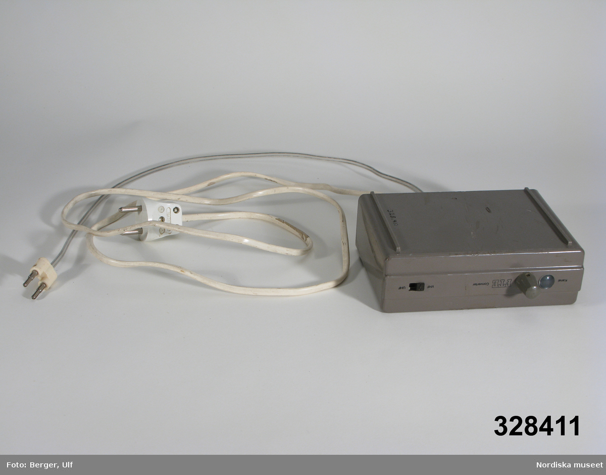 Lådformad lös antennförstärkare med sladd till TV:ns antennurtag och sladd till "vanlig" strömförsörjning. På framsidan kanalväljare och omkopplare till VHF och UHF. På baksidan urtag för inkoppling UHF och VHF. Hör till tevemöbel inv.nr 328409.
/Ulf Hamilton 2006-05-16   
