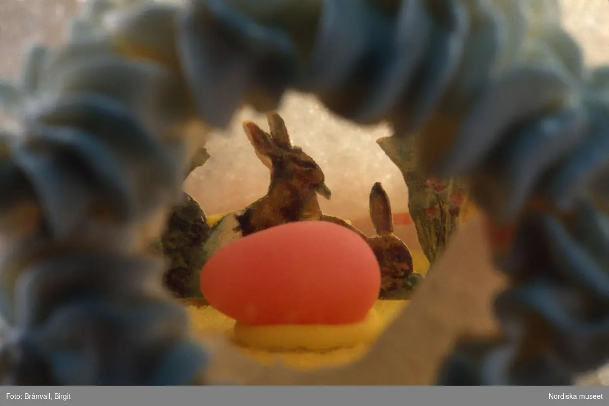 Påskägg. Inuti ett tittägg av sockerkristyr finns ett miniatyrlandskap med ägg och harar. Nordiska museets föremål inv.nr 242293.