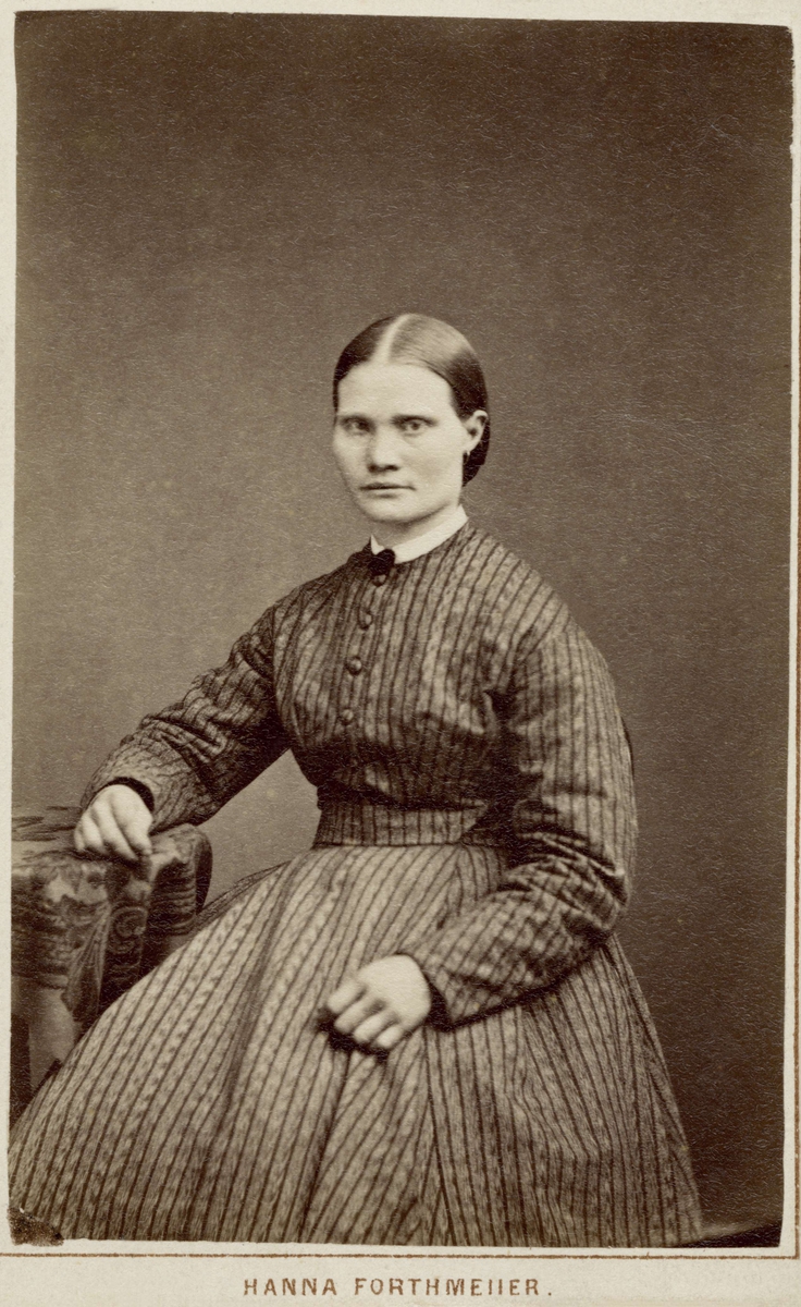 En ung kvinna poserar i en randig klänning