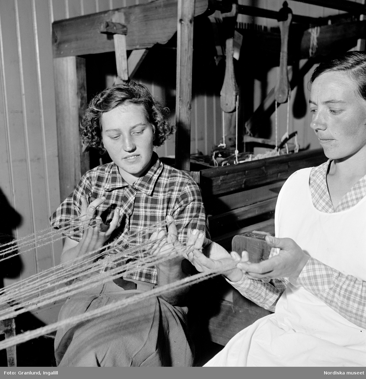 Tillverkning av bögsäcksfässlor, vävning, flätning, slingning, i Gruddbo by. Interiör med två arbetande kvinnor.