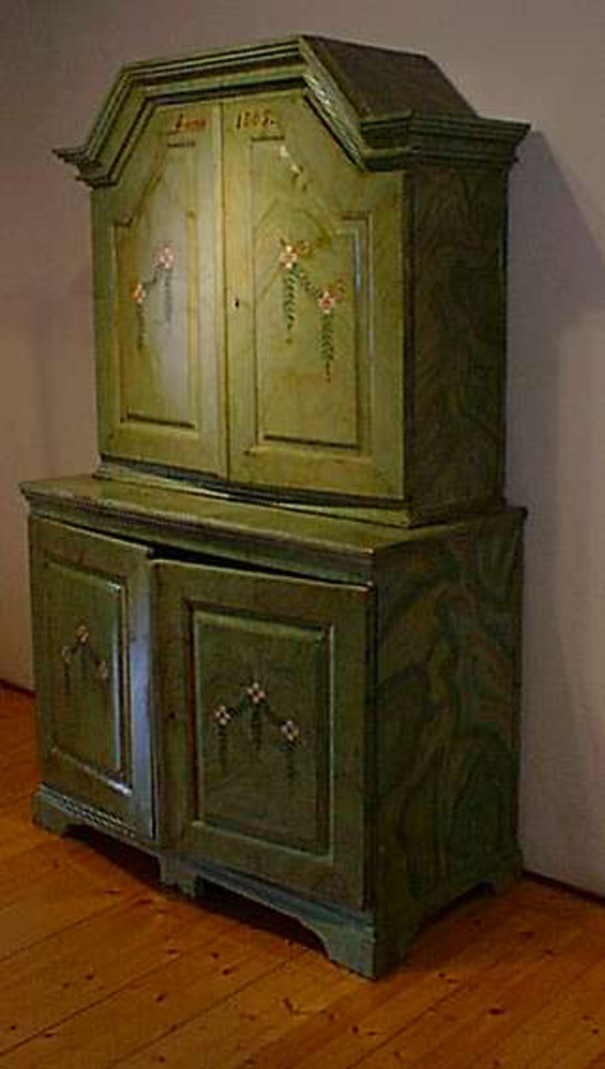 Skåp. Marmorerat i ljusgrönt och brunt. På skåpdörrarna blomrankor. Överst står ANNO 1805. Inredning i överskåpet fyra hyllor och två lådor, underskåpet två hyllor.