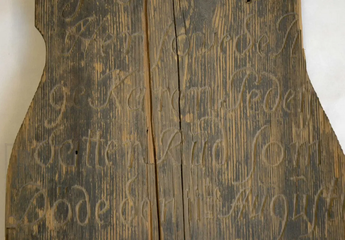 Svartmalt gravminne med innskåret skrift. Sekundært gavltak (laget og påsatt i forb. med utstilling i våpenhuset i 1970).