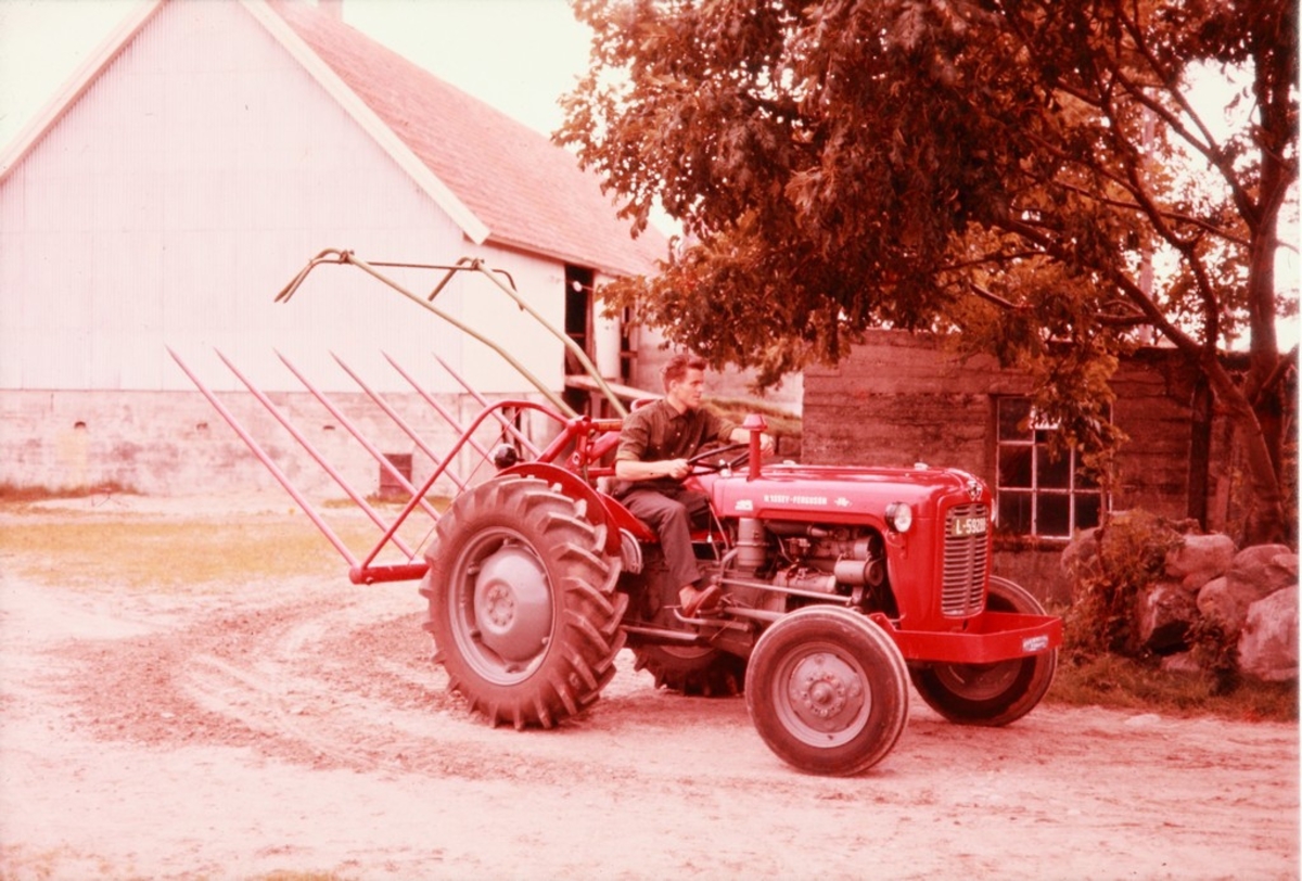 Traktor med løftet høysvans fra Kvernelands Fabrikk AS på gården Frøyland, Torstein Salte på traktoren