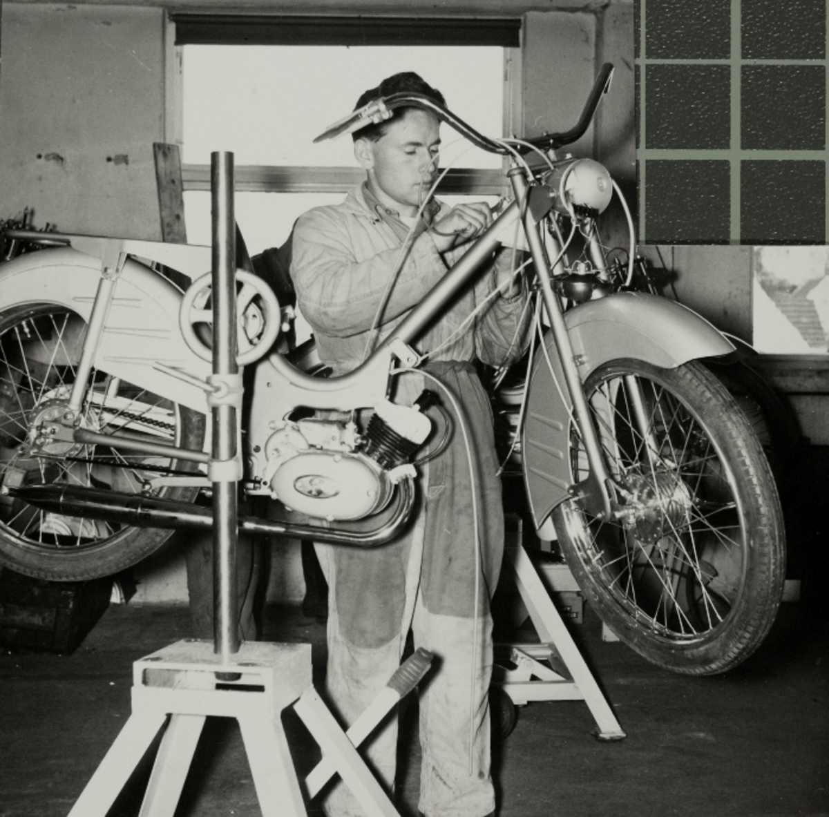 Leif Hetland setter på styre, lykt og kabeltrekk på en TEMPO-Lett moped.