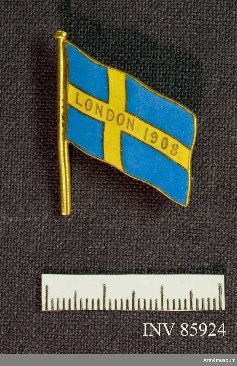 Grupp M II.
Brosch i form av svensk flagga buren av Oscar Gomer Swahn under Olympiska spelen i London 1908.
