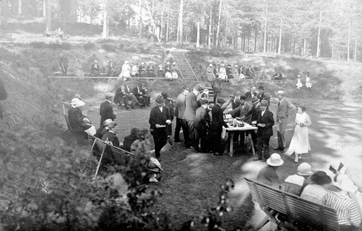 Männniskor dricker kaffe på stor plan med kaffebord i mitten och soffor och bänkar runt om, i skogen vid Lungkliniken i Eksjö.