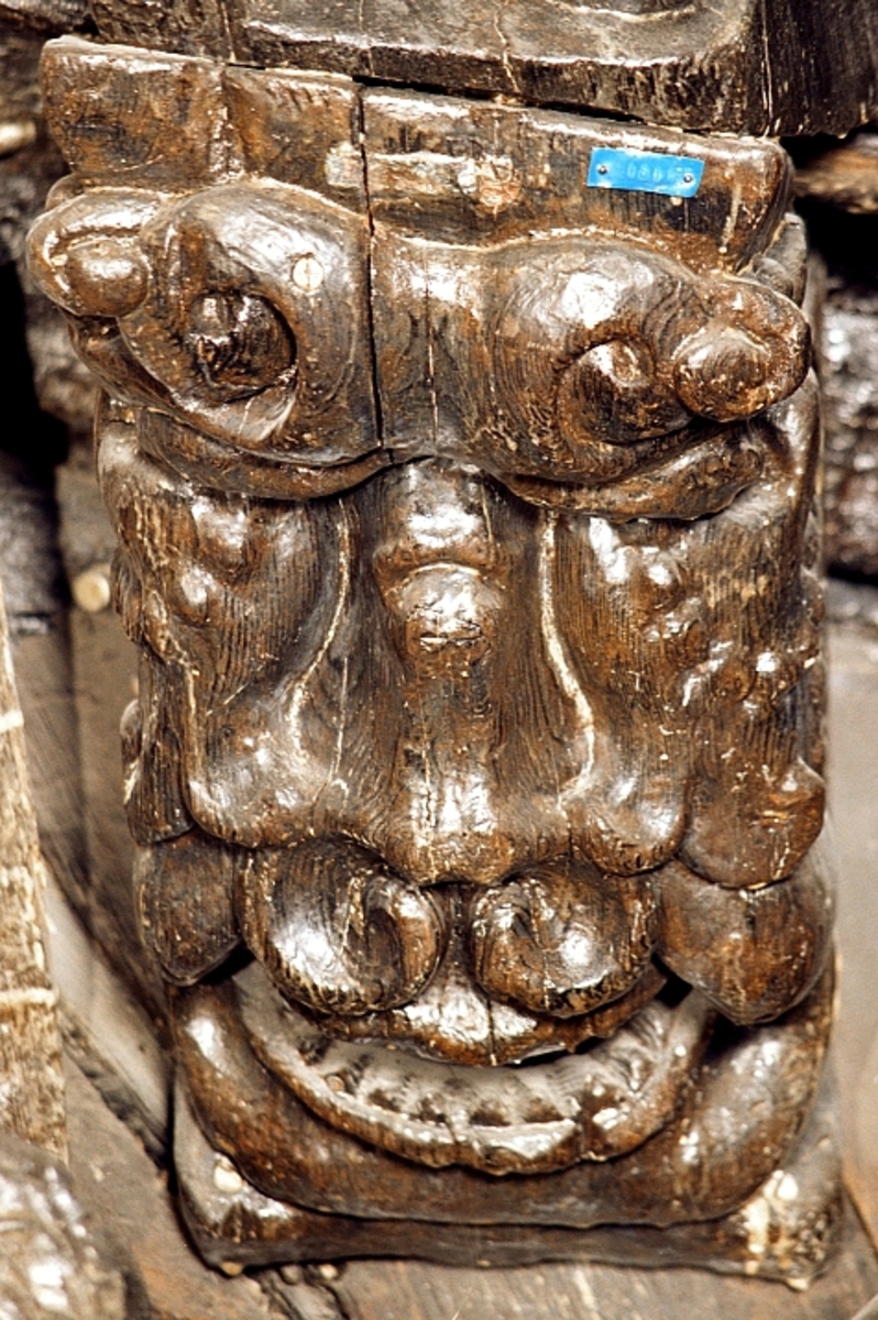 Del av ett skulpterat manshuvud. Separat snidad bakre del.

Text in English: Part of sculpted male forehead. The back of the head was carved separately.