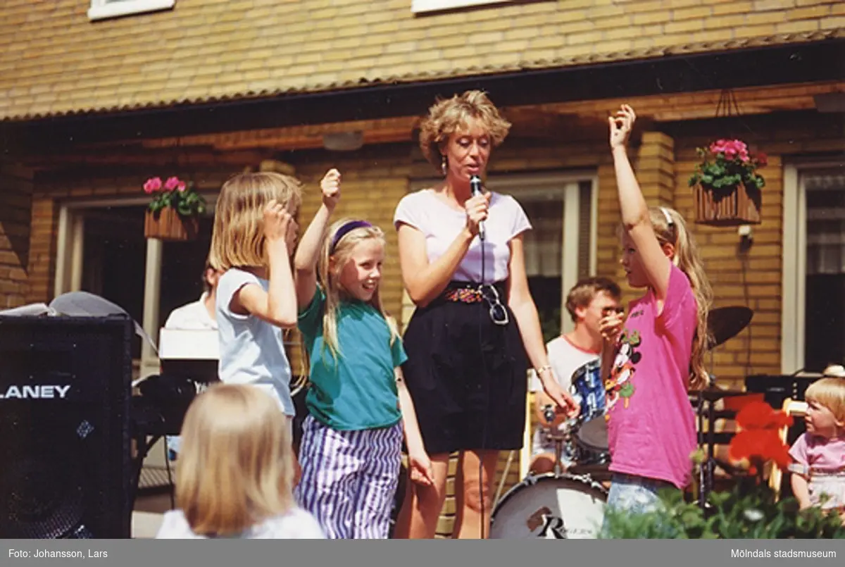 En av bostadsrättsföreningen Tegens gårdsfester i Kvarteret Rullharven 1989. Man hade bland annat korvservering, poängpromenad, spel, tävlingar, sång- och musikunderhållning m.m. Sångerskan heter Birgit Hansen, då boende i Bifrost (men inte resten av bandet).