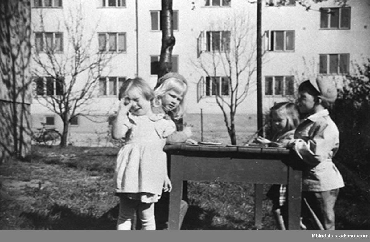 Fyra barn utomhus vid Krokslätts daghem, Dalhemsgatan 7 i Krokslätt 1949. Bostadshuset i bakgrunden är Dalhemsgatan 10 - 12.