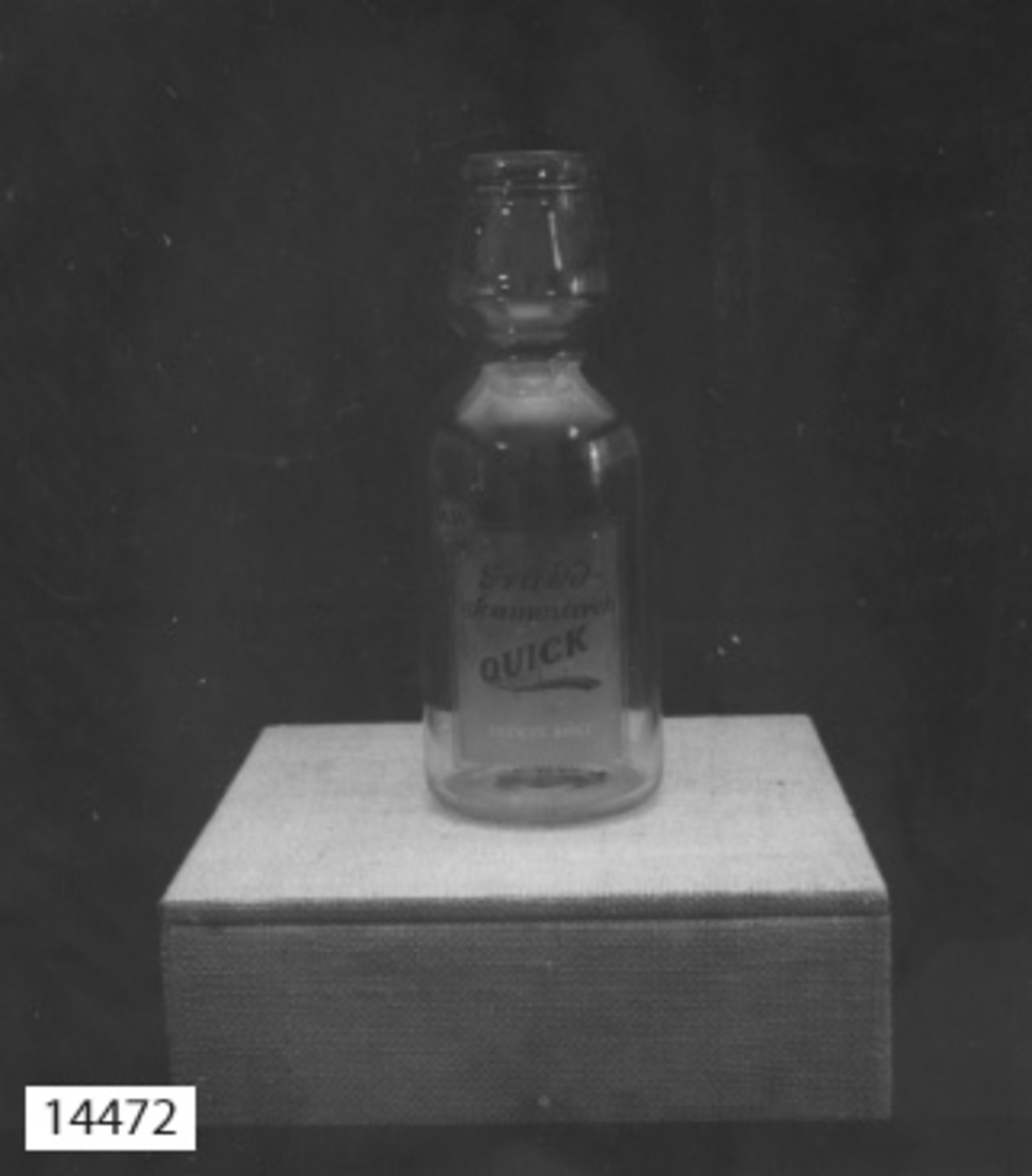 Gräddskummare, glas. har formen av en flaska med en "gräddhals". textat på glaset: Gräddskummare Quick. Patent sökt. M & W  A.-B. STOCKHOLM.