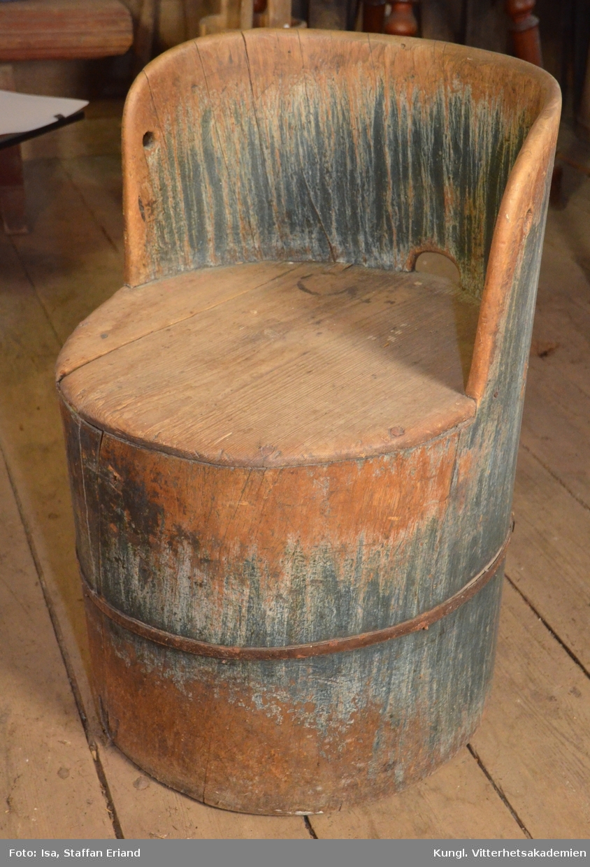 Stol, kubbstol.Materialet i stolen är granträ, där en hel stock har urholkats. Stolen är således inte laggad. Som förstärkning har järnband monterats runt stolen. Ryggstödet har halvrund form med bågformad genomskärning mitt på ryggen som ett fungerande  handtag vid förflyttning av stolen. Sitsen består av en rund träplatta infälld i stocken. Stolen har spår av blå färg,

fr. Floda sn. Dalarna