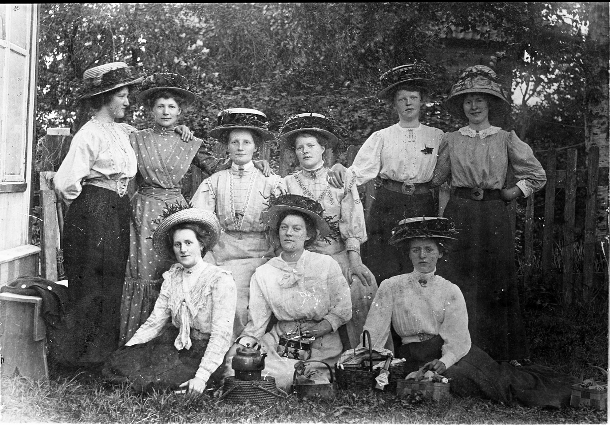 kvinner hattar blusar skjørt kaffikjel korger benk hage