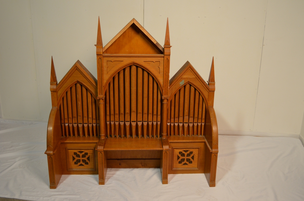 Kirkeorgel med toppstykke. Toppstykket har utskore orgelpiper. Det er ikkje ekte orgelpiper, men illustrasjonar skore ut i tre.