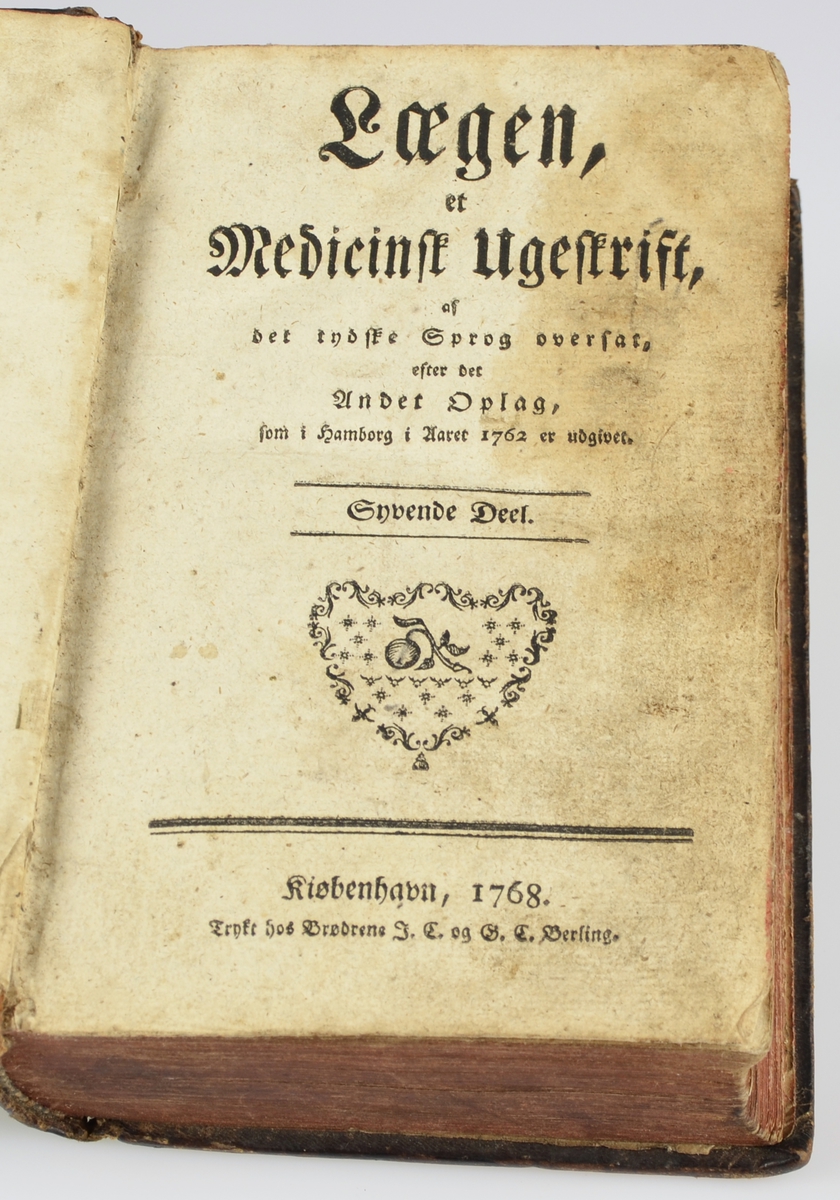 Lægen, et Medicinsk Ugeskrift af det tydske Sprog oversat, efter det Andet oplag, som i Hamburg i Aaret 1762 er udgivet.406 s. Skinnbind. Ryggen delt i 6 liggande rektangulære felt over kvarandre.