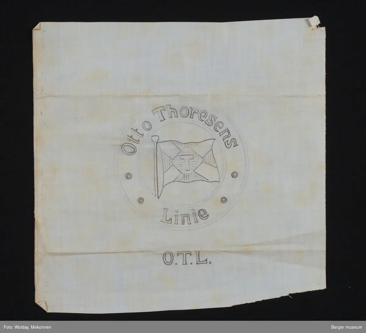 Sirkel med skrevet Otto Thoresens Linie med flagget med bokstaven T i midten. Under står det skrevet O.T.L.