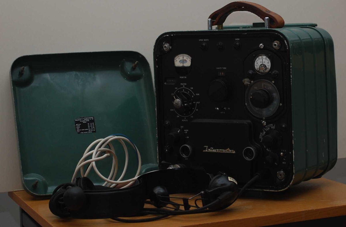 Tellurometer med deksel og to hodetelefoner og batteriledning