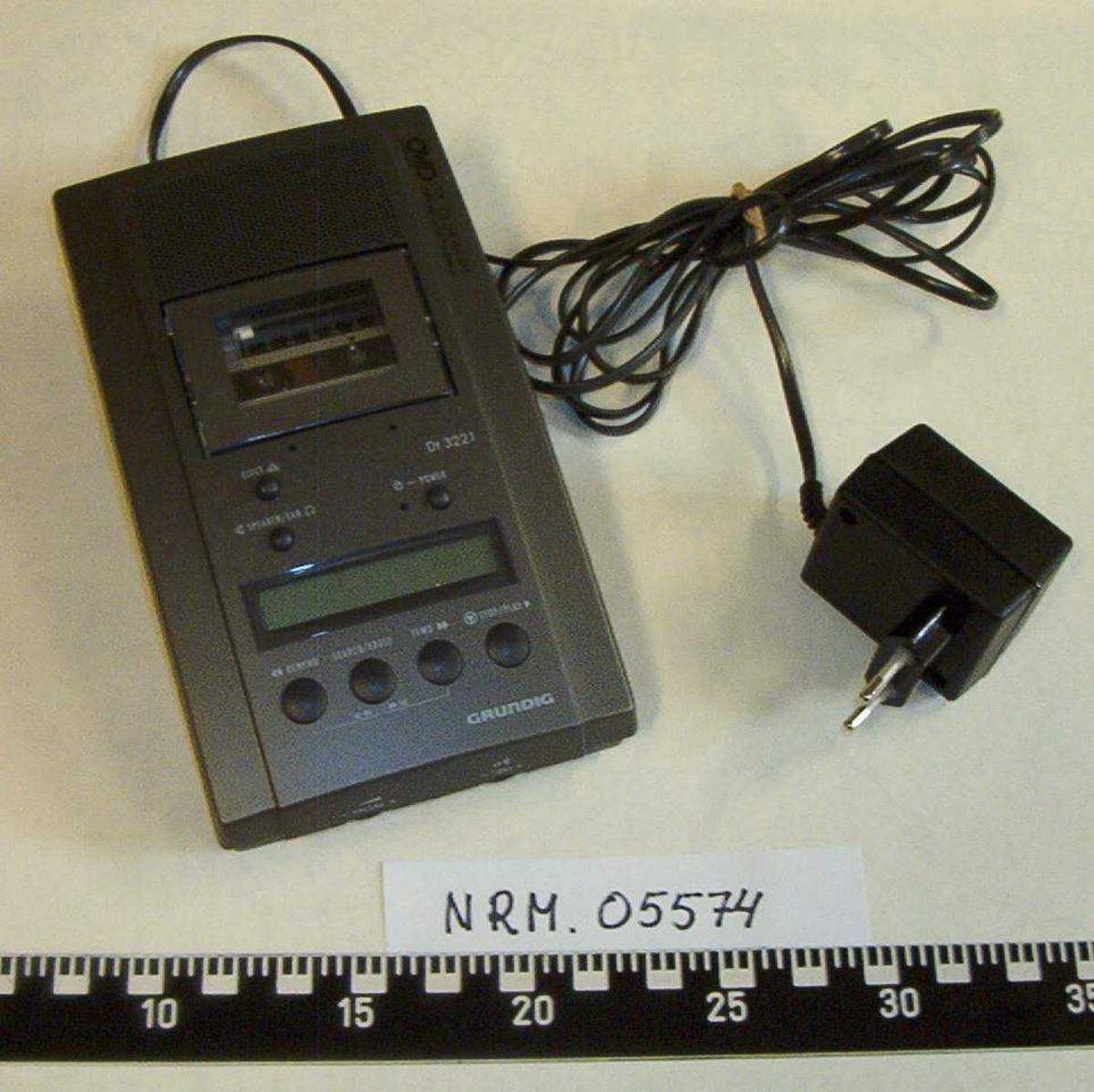 Lydbåndopptaker i tre deler:

NRM.05574a:  1 Opptaker Grundig dt. 3221,
                         CMP Kontor og Data Trondheim,
                         med tilhørende adapter.
NRM.05574b:  1 Fotpedal Grundig, Type 535B, 
                         med ledning for tilkobling opptaker.
NRM.05574c:  1 Headset Grundig, 
                         med ledning for tilkobling opptaker.