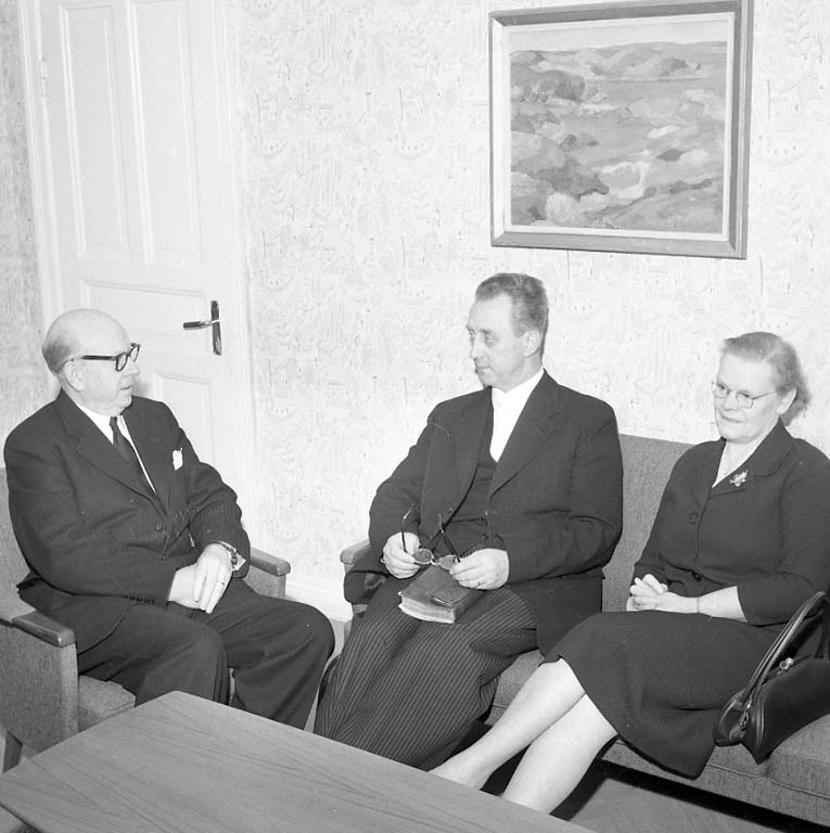 Tre personer sitter i en soffgrupp, från vänster distriktsföreståndare  Herbert Johnsson samt paret pastor Bertil Eriksson och fru Ebba Eriksson.