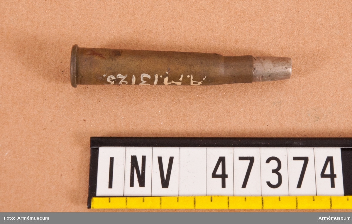 Grupp E V.
7,5 mm skarp patron, märkt R.L/VII. Till engelskt armégevär. Lik AM 47372, men med spetsen nedfilad till dumdumkula. Från första världskriget.