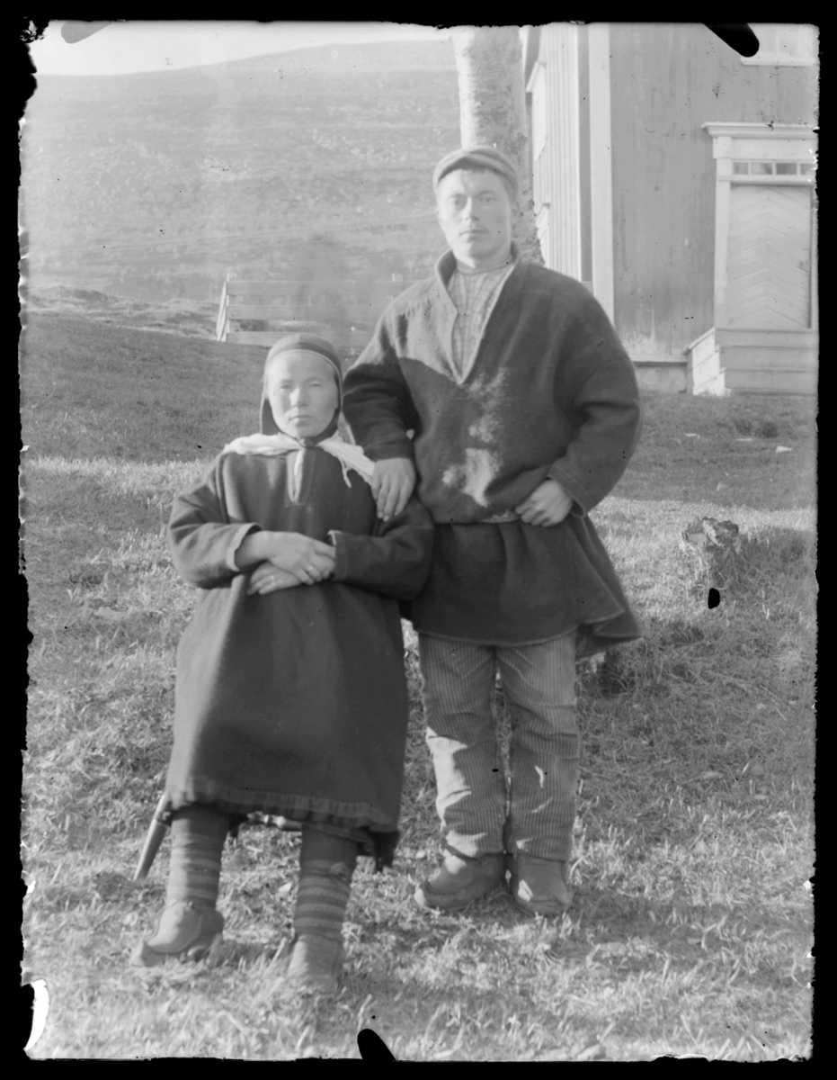 Samisk kvinne og mann fotografert ute, antakelig på Langnes i Tana