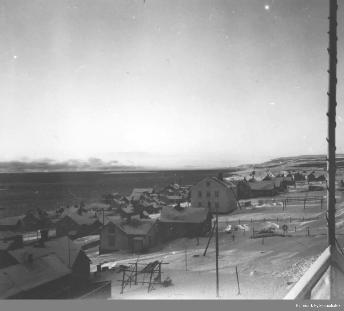 Utsikt mot Indrebyen i Vadsø med lille Vadsøya i bakgrunnen og førkrigsbebyggelse i forkant.