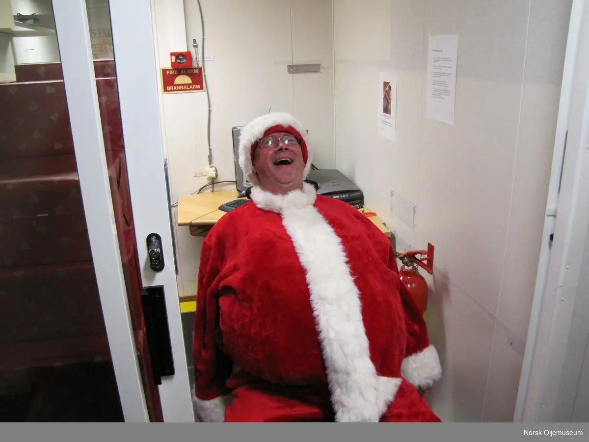 Julefeiring på Valhall og nissen, Helge Waage sitter klar for utdeling av gaver til de ansatte.