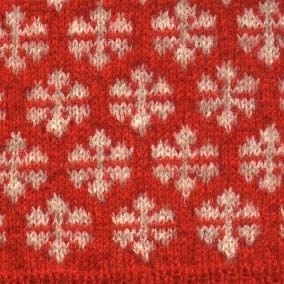 Väst stickad i 2 trådigt rött ochnaturvit ullgarn
Brearedsmönster i vitt på röd botten.
Ärmhål,halsringning och nederkant i röd resårstickning