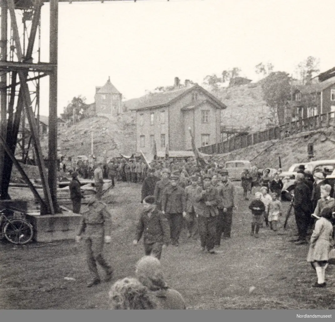 Sovjetiske ekskrigsfanger masjerer til kaia ved hjemreisen. Bildet er fra Finneidkaia. Toldergården kan ses i bakgrunnen.